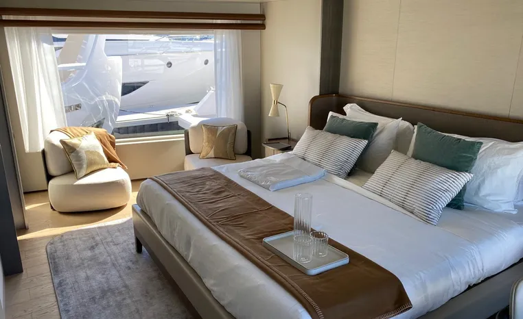 Luxurious bedroom interior of 2024 Azimut Magellano 30M yacht with elegant decor and large window.