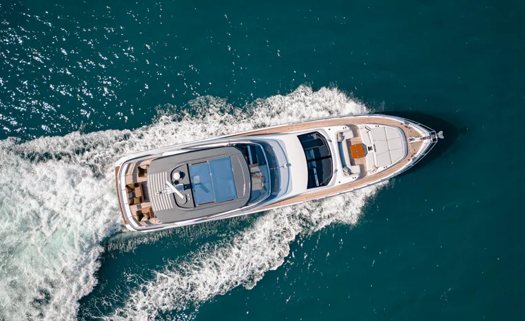 Aerial view of 2025 Azimut Fly 78 yacht cruising on blue ocean waters.