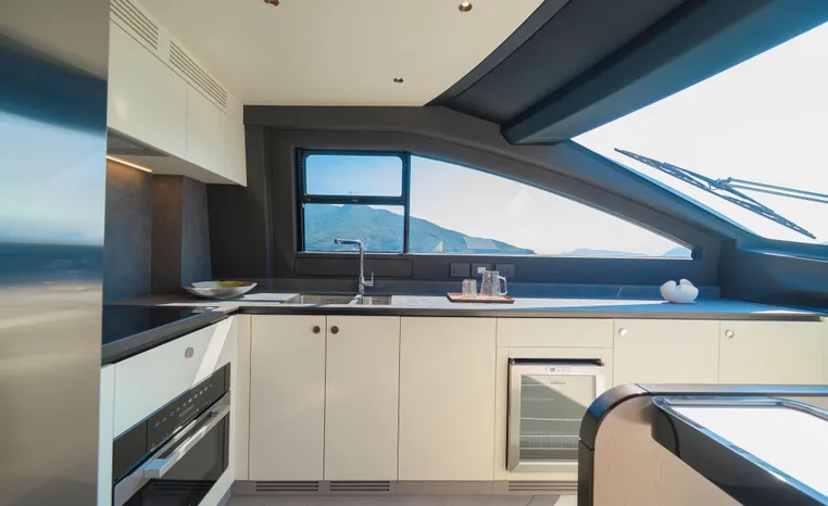 Modern kitchen interior of 2025 Azimut Fly 78 yacht with scenic window view.