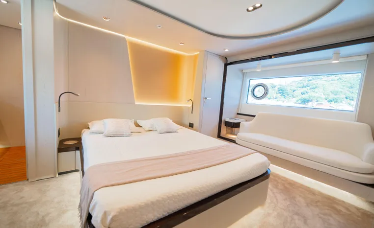 Luxurious bedroom interior of 2025 Azimut Fly 78 yacht with modern design and large window.